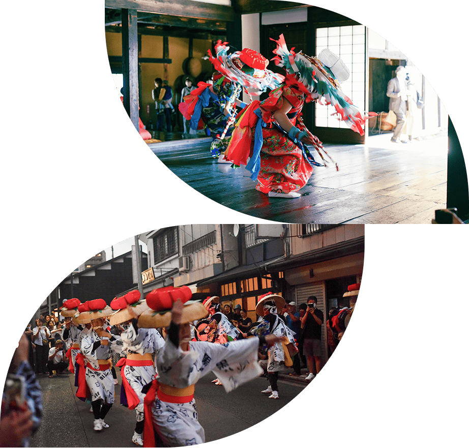 伝統的な衣装を身にまとい、室内で力強く踊る踊り手たち。観客が見守る中、鮮やかな飾りが舞う。